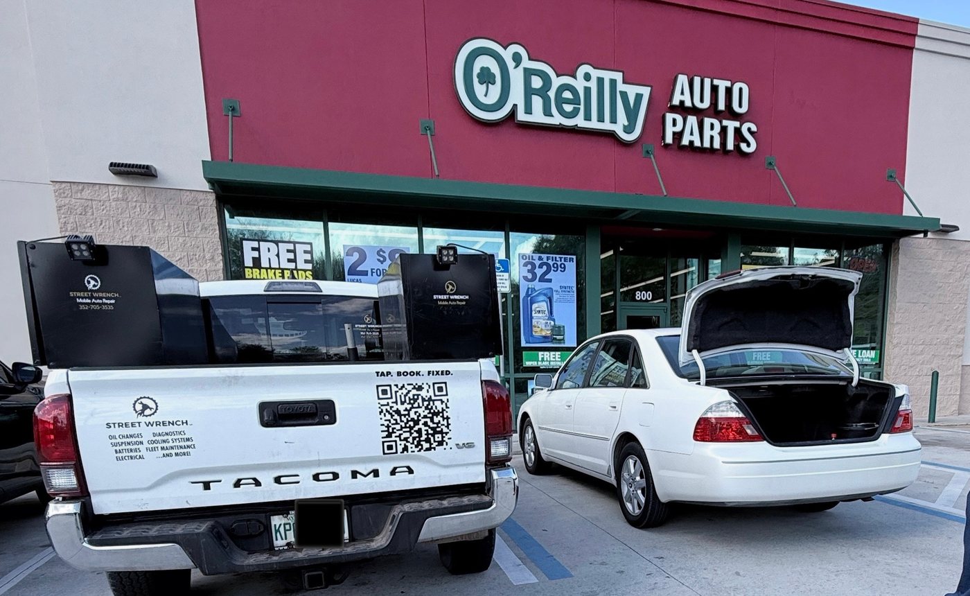 Street Wrench truck at an auto parts store with customer vehicle nearby